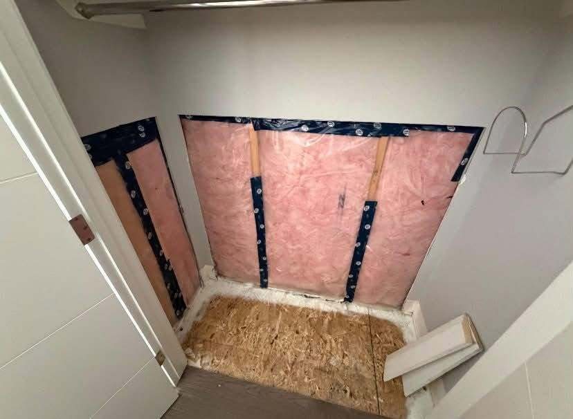 Closet stripped back to insulation and subfloor before drywall repair and paint
