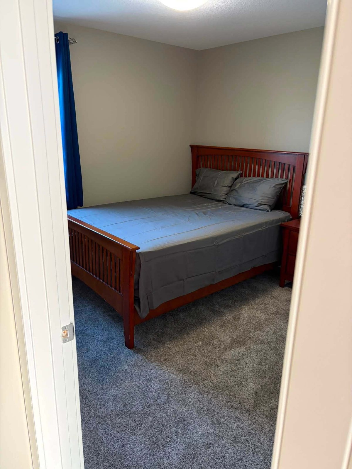 Bedroom with blue curtains and freshly painted walls