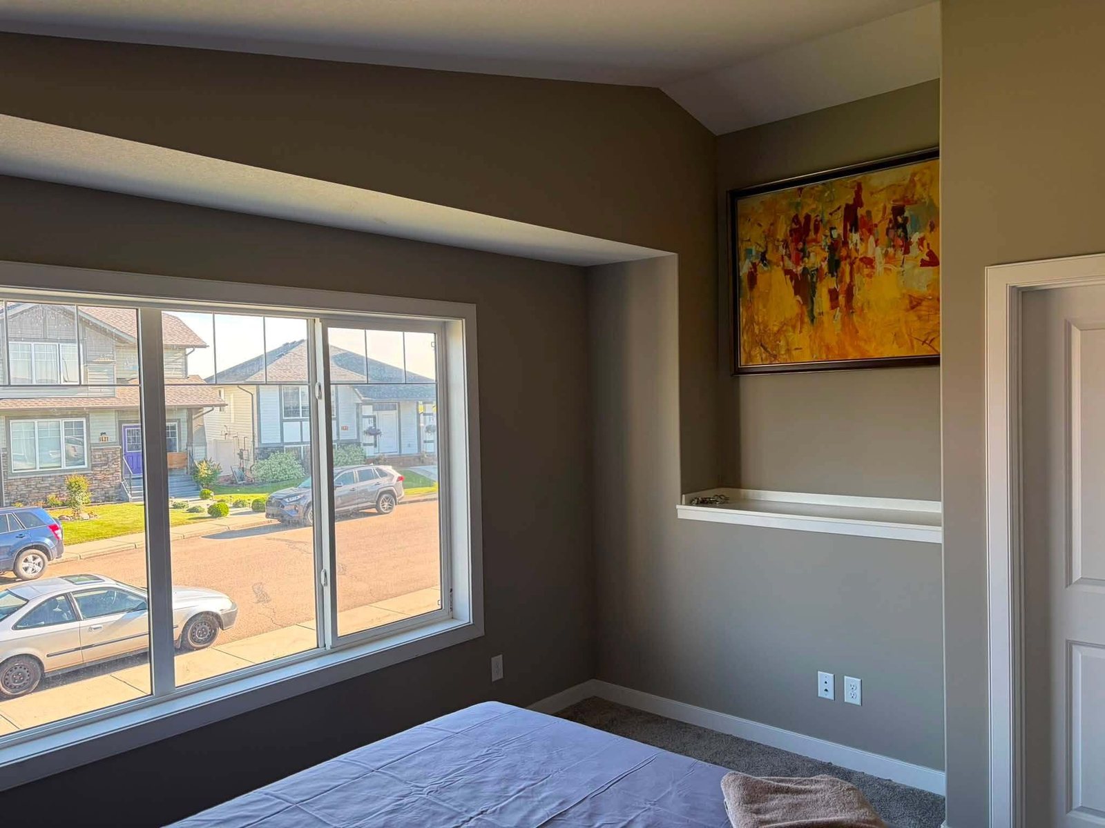 Bedroom with a wide picture window and fresh neutral wall paint