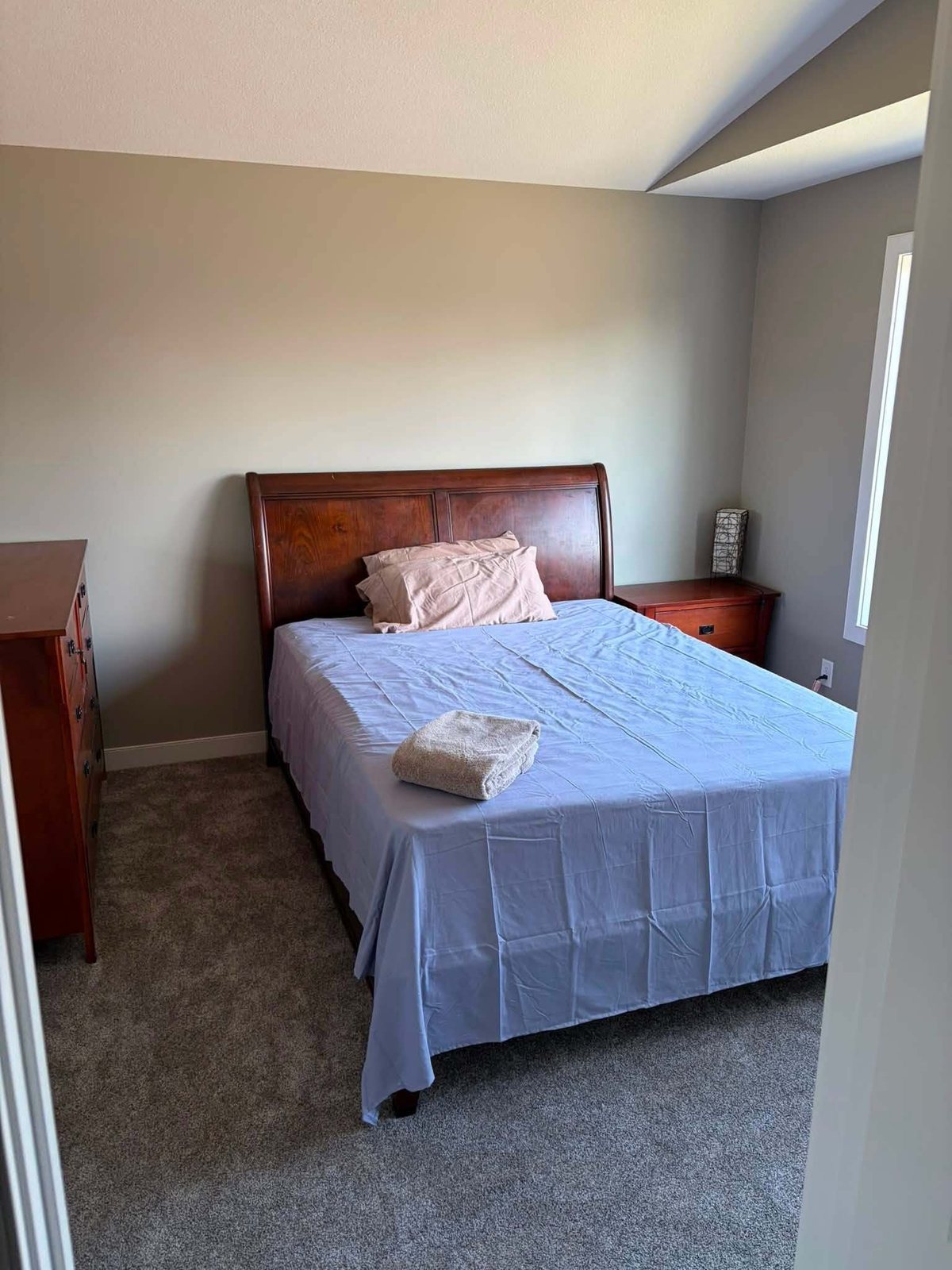 Bedroom with a wood sleigh bed and fresh wall paint