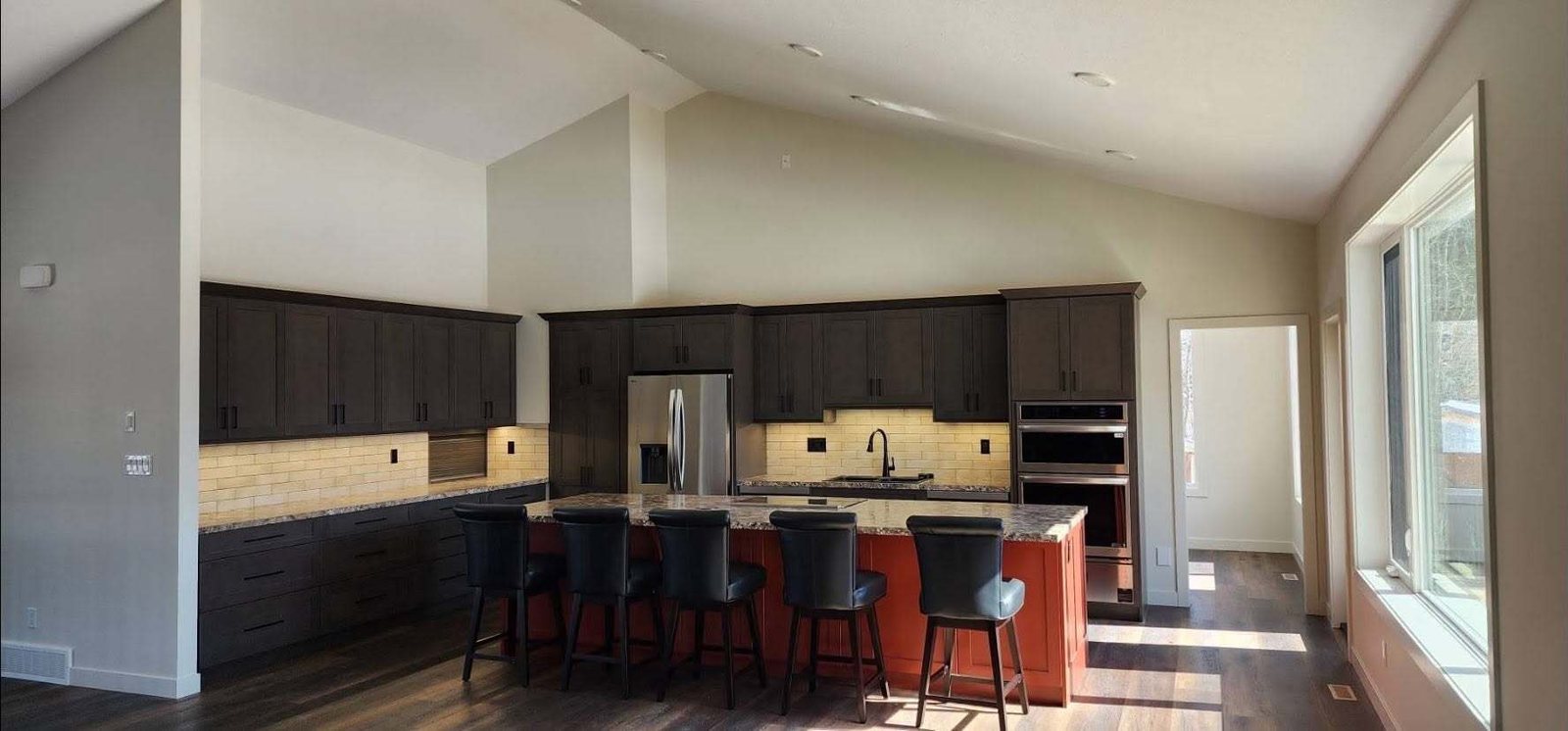 Kitchen with a large island in a new Lacombe County home, walls freshly painted
